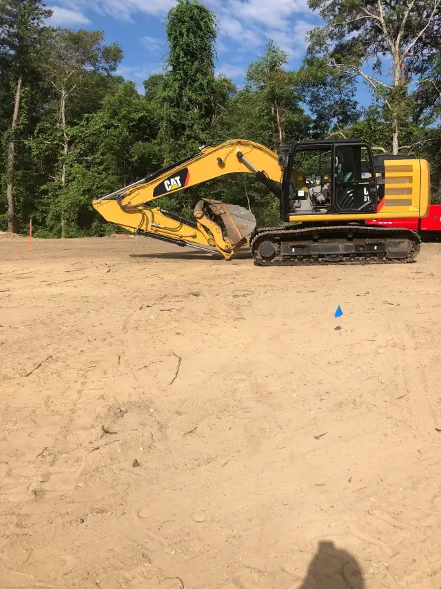 Excavator clearing a lot