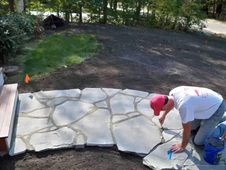 Mason setting a flagstone patio