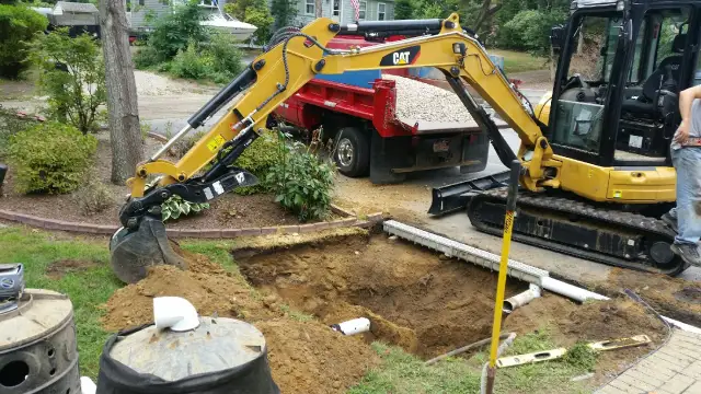 Mini excavator digging for drainage and irrigation work