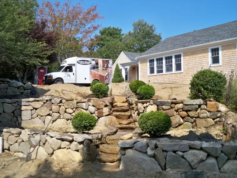 Natural stone retaining wall and steps under construction