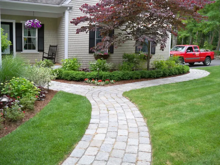 Curving paver walkway and plantings at a Cape home